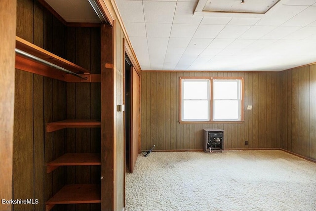 unfurnished bedroom with carpet floors and wooden walls