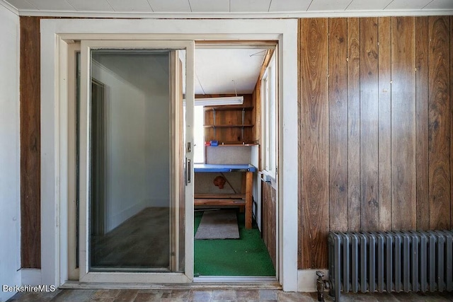 interior space featuring radiator heating unit and wood walls