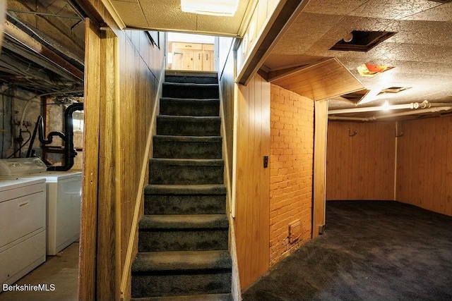 stairs featuring carpet flooring, wooden walls, and independent washer and dryer