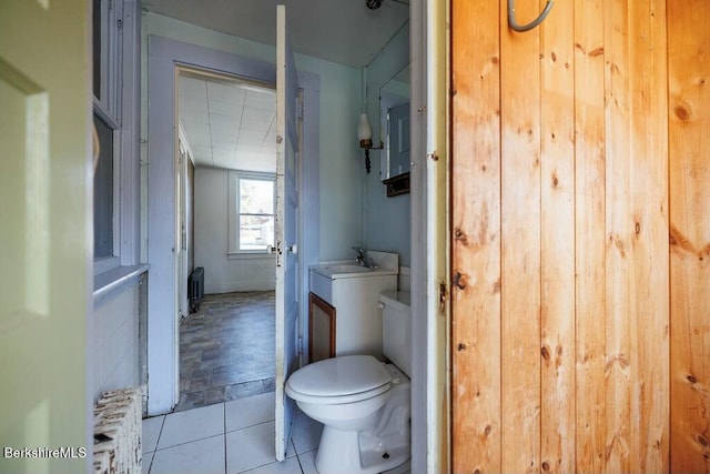 bathroom with tile patterned flooring, toilet, sink, and radiator