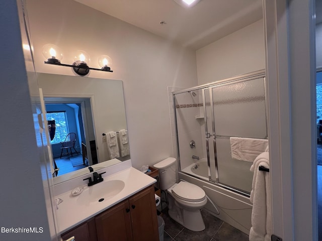 full bathroom with toilet, vanity, tile patterned floors, and enclosed tub / shower combo