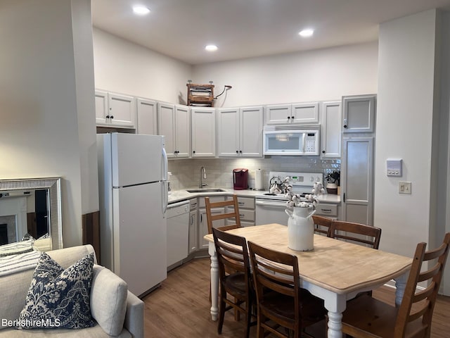 kitchen featuring white cabinetry, decorative backsplash, sink, and white appliances