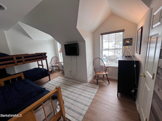 bedroom with vaulted ceiling and light hardwood / wood-style flooring