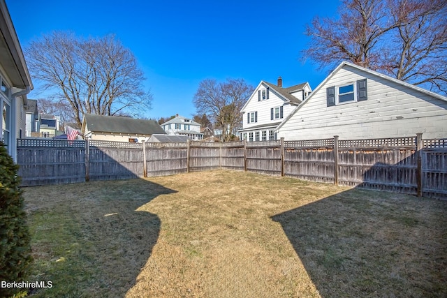 view of yard featuring a fenced backyard and a residential view