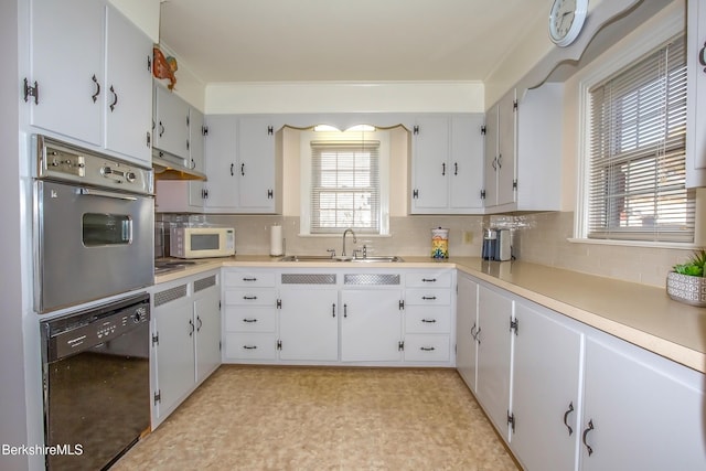 kitchen featuring a sink, black dishwasher, backsplash, stainless steel oven, and white microwave