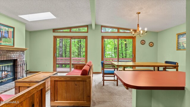 15 Elk Dr, Lee, MA 01238 - carpeted living room with a brick fireplace, a chandelier, a textured ceiling, a skylight, and lofted ceiling