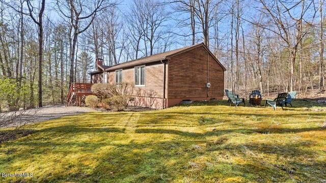 15 Elk Dr, Lee, MA 01238 - view of side of home featuring a chimney, a wooden deck, a fire pit, a yard, and stairway