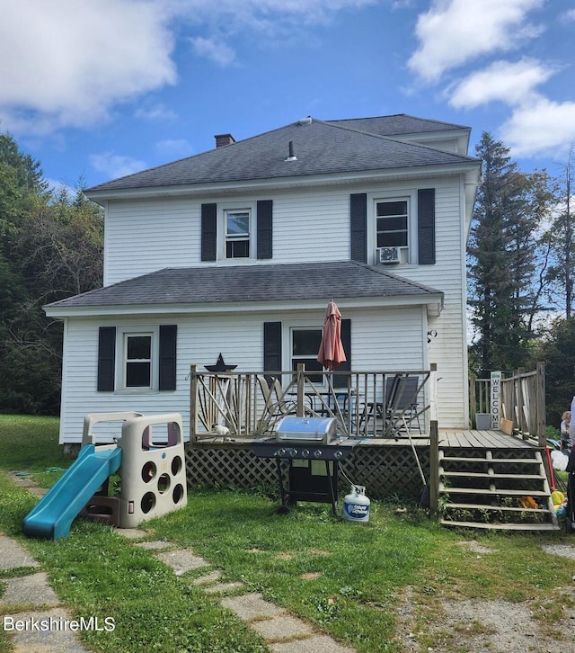 back of property featuring a wooden deck and a yard