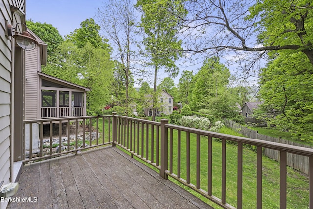 wooden deck featuring a sunroom and a yard