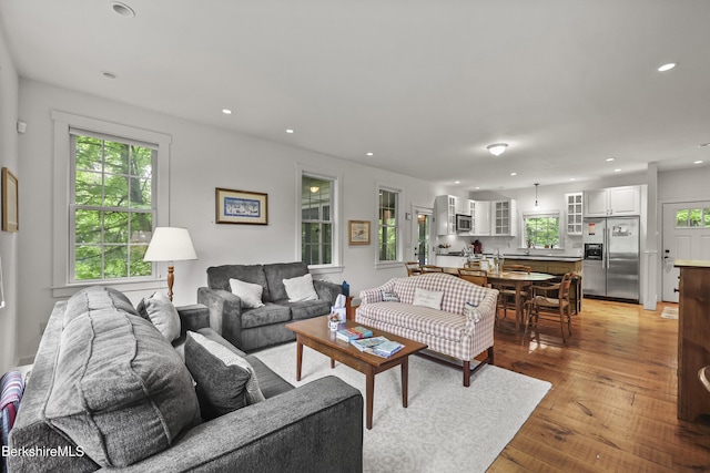 living area with healthy amount of natural light, light wood-style flooring, and recessed lighting