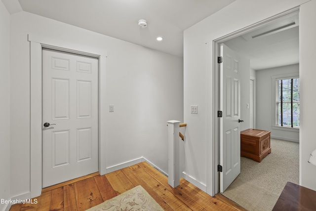 corridor featuring an upstairs landing, recessed lighting, light wood finished floors, and baseboards