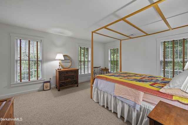 carpeted bedroom featuring multiple windows and baseboards