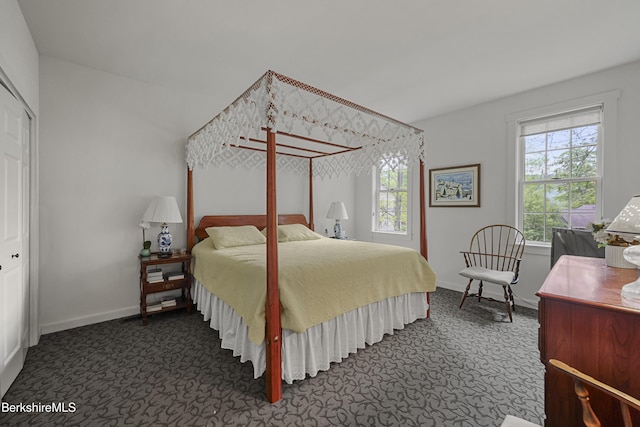 bedroom featuring dark colored carpet and baseboards