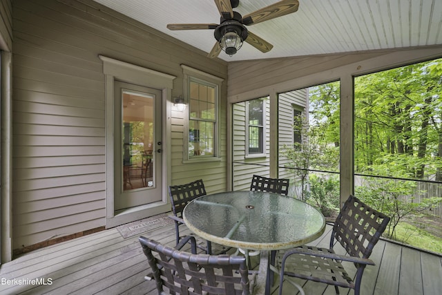 sunroom / solarium with a ceiling fan and outdoor dining space