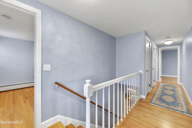 hallway with light wood-type flooring and a baseboard radiator