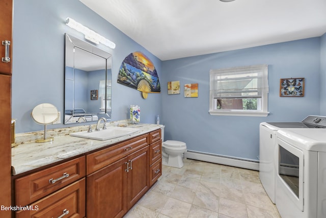 bathroom featuring toilet, vanity, separate washer and dryer, and a baseboard radiator