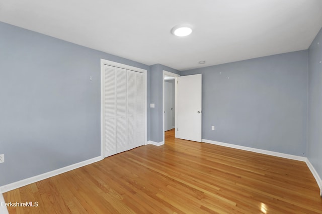 unfurnished bedroom with wood-type flooring and a closet