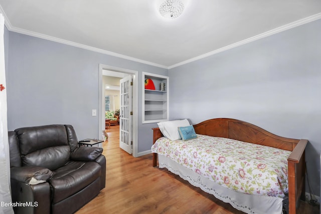 bedroom featuring wood-type flooring, french doors, and crown molding