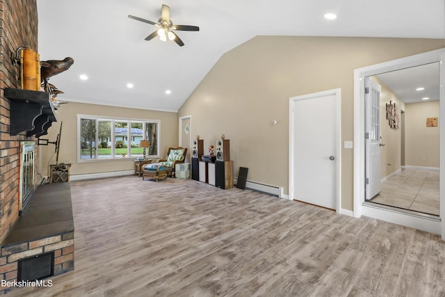 interior space with a fireplace, light hardwood / wood-style flooring, ceiling fan, and lofted ceiling