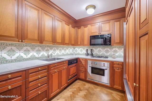 kitchen with light stone countertops, appliances with stainless steel finishes, backsplash, light parquet floors, and sink