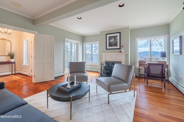 living room with light hardwood / wood-style floors, baseboard heating, and crown molding