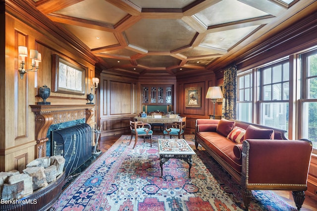 sitting room featuring a fireplace, crown molding, wooden walls, and coffered ceiling