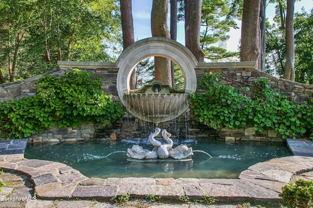 exterior details with a garden pond