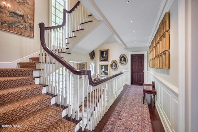 stairway with wood-type flooring and ornamental molding