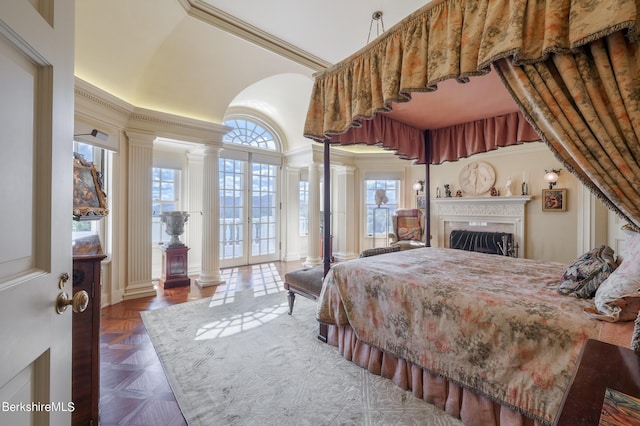 bedroom with dark parquet flooring, ornate columns, french doors, access to exterior, and a premium fireplace