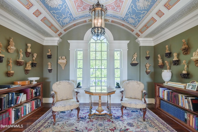 living area with an inviting chandelier, dark hardwood / wood-style flooring, decorative columns, vaulted ceiling, and ornamental molding