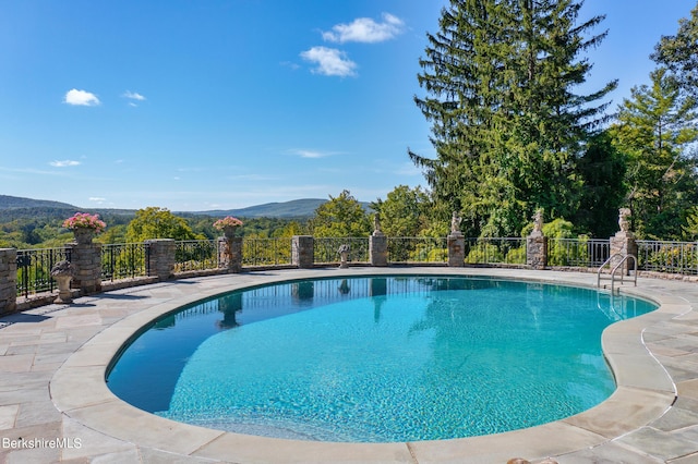 view of swimming pool with a mountain view