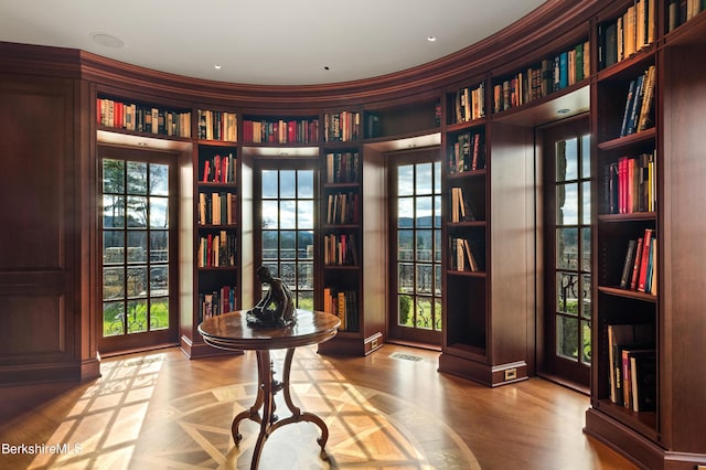 sitting room with hardwood / wood-style flooring and built in features