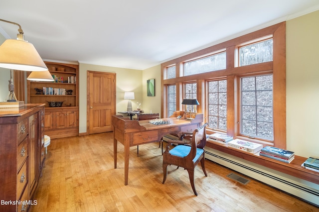 office featuring ornamental molding, baseboard heating, and light hardwood / wood-style flooring