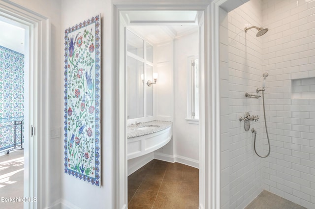 bathroom featuring a tile shower and vanity