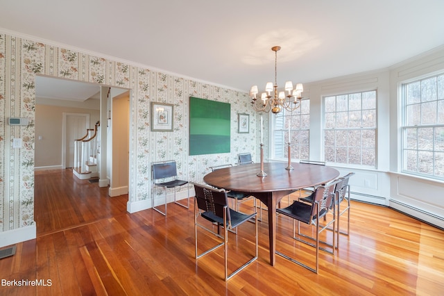 dining space featuring hardwood / wood-style flooring, an inviting chandelier, and crown molding