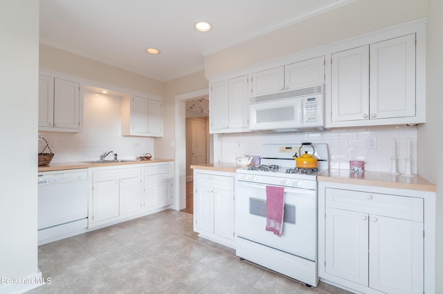 kitchen featuring white appliances, white cabinets, crown molding, sink, and decorative backsplash