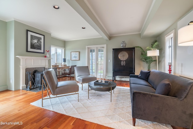 living room with beamed ceiling, ornamental molding, and light wood-type flooring