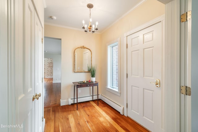 foyer featuring plenty of natural light, an inviting chandelier, light wood-type flooring, and ornamental molding