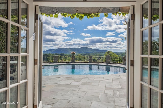 view of swimming pool with a mountain view and a patio area