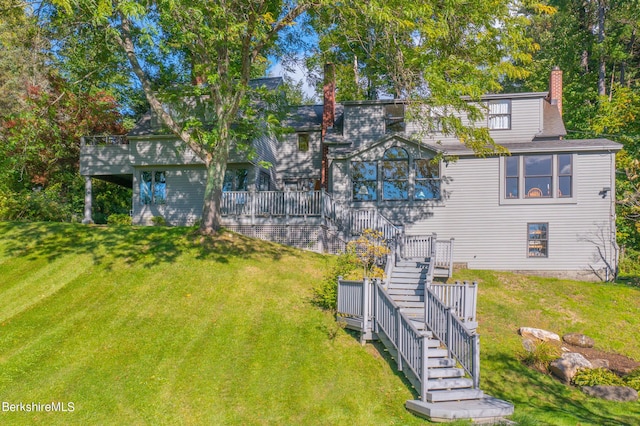 rear view of house featuring a deck and a yard