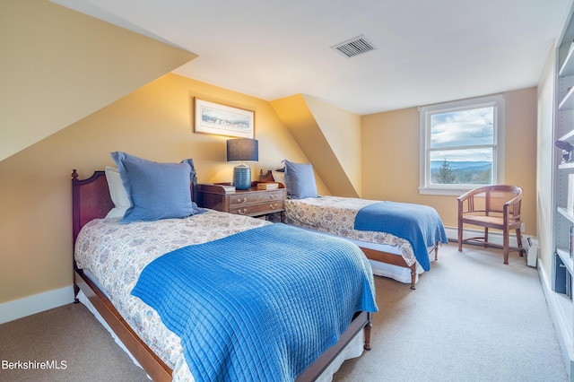 bedroom with baseboard heating and light carpet