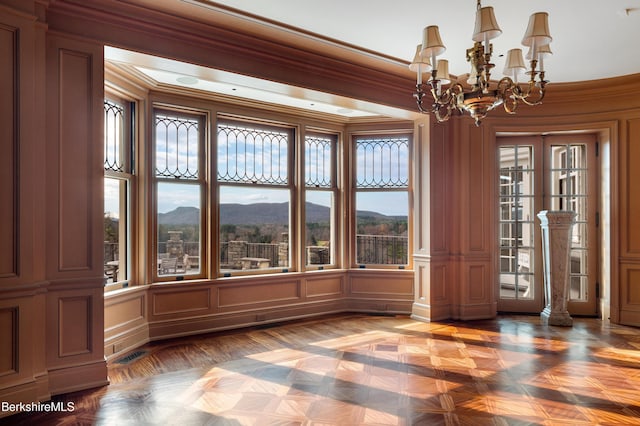 unfurnished sunroom with a mountain view and a notable chandelier