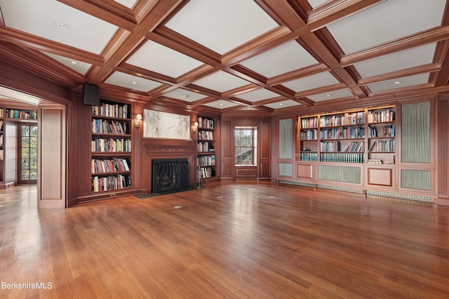 interior space featuring coffered ceiling, built in shelves, wooden walls, beam ceiling, and hardwood / wood-style floors