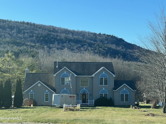 view of front of property featuring a mountain view and a front yard