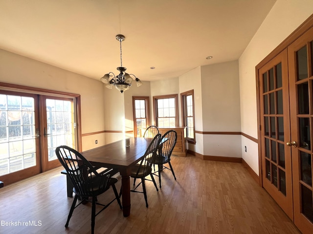 dining space featuring a chandelier, french doors, and dark wood-type flooring