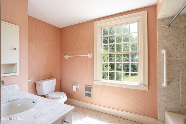 bathroom featuring vanity, heating unit, and toilet