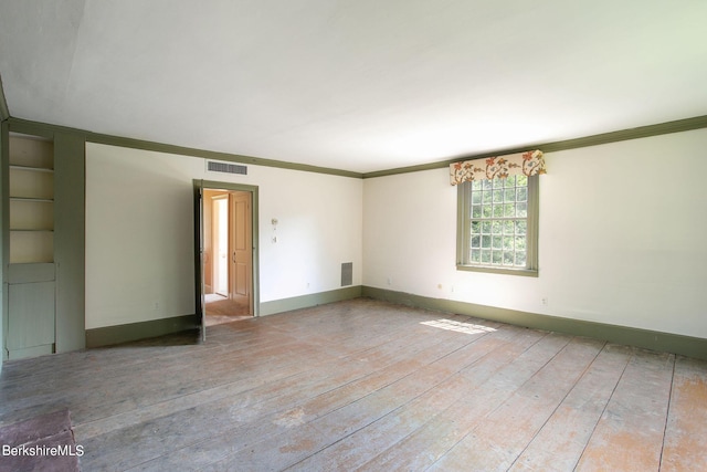 empty room featuring crown molding and light hardwood / wood-style floors