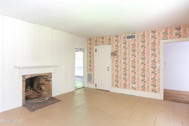 unfurnished living room featuring a brick fireplace