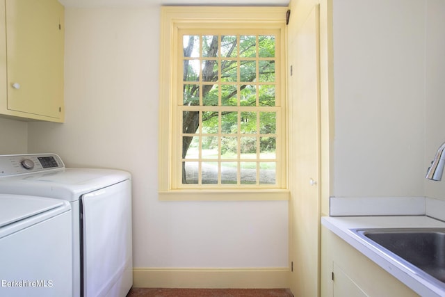 clothes washing area with washer and dryer, sink, and cabinets