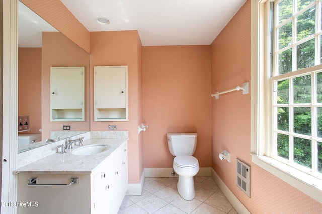 bathroom featuring heating unit, tile patterned flooring, vanity, and toilet